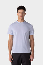 A young man with short dark hair wears the 686 Mens Everywhere drirelease® Tech Tee in light gray and black pants, standing against a plain white background, facing forward with a neutral expression.