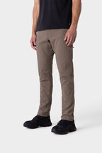 A person wearing a black t-shirt, black sneakers, and 686 Men's Everywhere® Merino-Lined Pant - Slim Fit in khaki stands against a plain white background. The photo is cropped from shoulders down, showing an outfit suited for warm, dry weather.