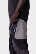 A traveler slips a passport into the pocket of their 686 Men's Anything Cargo Pant - Slim Fit, by 686, ready for adventure.