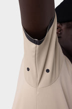 A close-up of a person in the 686 Men's Let's Go Tech Tee, featuring vented, breathable fabric and snap buttons under the arm. With only part of their face and a black beanie showing, it's ideal for spring-summer adventures.