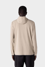 A person with short hair is seen from behind, wearing the 686 Mens Lets Go Tech Hoody in light beige and black cargo pants, set against a plain light gray background.