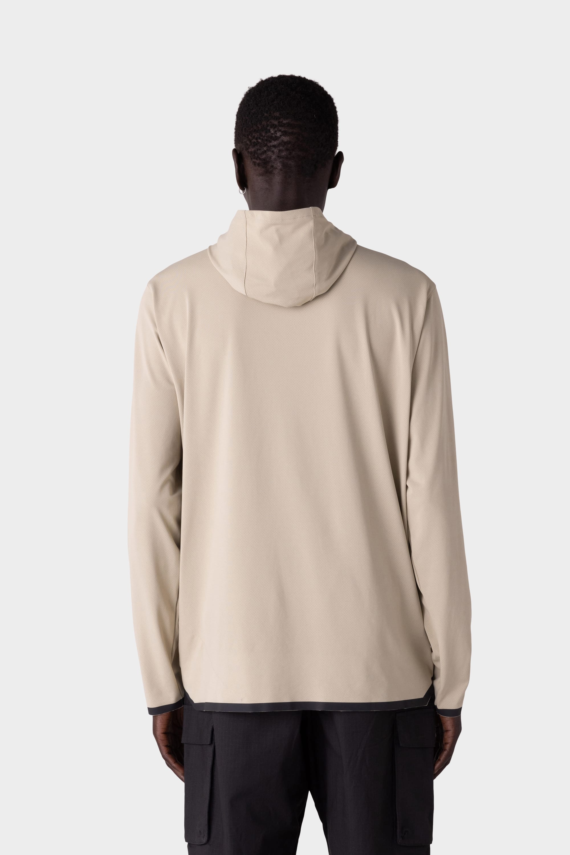 A person with short hair is seen from behind, wearing the 686 Mens Lets Go Tech Hoody in light beige and black cargo pants, set against a plain light gray background.
