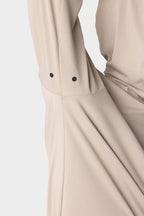 A close-up of the 686 Mens Lets Go Tech Hoody in beige shows its textured, lightweight fabric and a sleeve with two black snap buttons near the cuff, set against a white background.