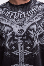 A close-up of the 686 Affliction Death Eyes SS Tee by 686, featuring "Affliction" in gothic letters above three skulls with wings and a large ornate cross at the center, plus the number 666 between the skulls.