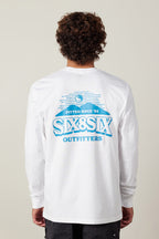 A person with curly hair, seen from behind, wears the 686 Fitted Authentic L/S Tee. This men's white long-sleeve shirt is 100% cotton and features a blue back graphic reading "Fitted Since 92," "SIX8SIX," and "OUTFITTERS.