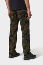 A person stands facing away in 686 Men's Everywhere® Merino-Lined Pant - Relaxed Fit, black shoes, a black t-shirt, and a stylish insulated jacket, all set against a plain white background.