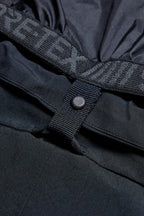 Close-up of the 686 Men's SMARTY® 3-in-1 Cargo Pant shows the waistband with GORE-TEX text, a snap button on a fabric loop, and detailed stitching—with a removable sweatpant liner for three ways to wear.