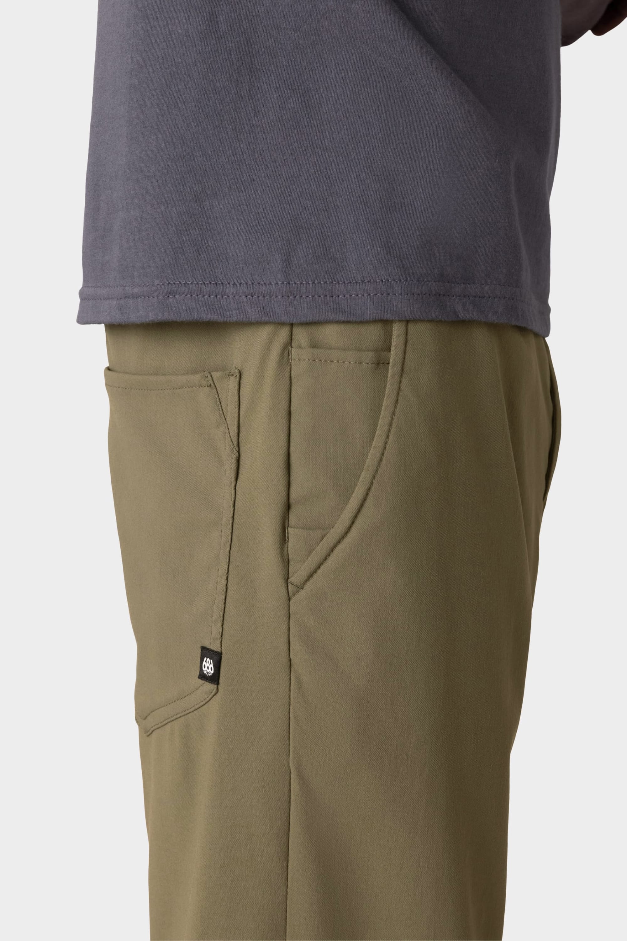 A person wearing a grey shirt and 686 Everywhere® Pant - Slim Fit by 686.