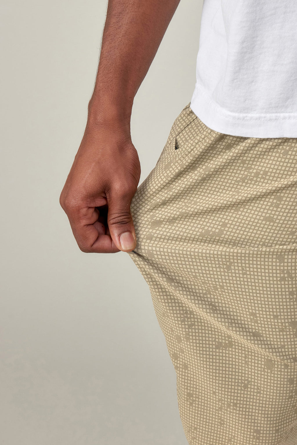 A person wearing a white shirt and 686 Men's Everywhere® Pant - Slim Fit stretches the fabric, showing off the impressive flexibility and stain-resistant material from 686.