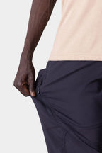 A person wearing the 686 Men's Anything Cargo Pant - Relaxed Fit pulls on the side to reveal a zippered pocket; only their arm and hip are visible.