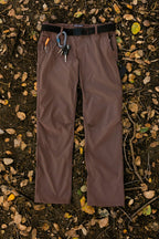 The 686 Men's Everywhere® Pant - Relaxed Fit by 686 features breathable fabric, a black belt, orange and blue carabiners, and keys on the belt loops—perfectly stain-resistant for outdoor adventures among yellow and brown leaves.