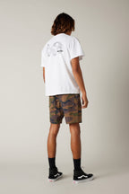A person faces away, wearing a white graphic tee, 686 Men's Everywhere® Hybrid Short by 686 in a camo print, black crew socks, and black Vans sneakers against a neutral background.