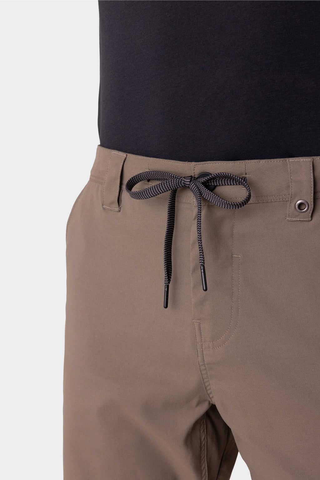 A person wears 686 Everywhere® Hybrid Short in light brown with a black and white cord at the waist, paired with a black shirt. The image highlights the waist and upper thigh area. Brand: 686.