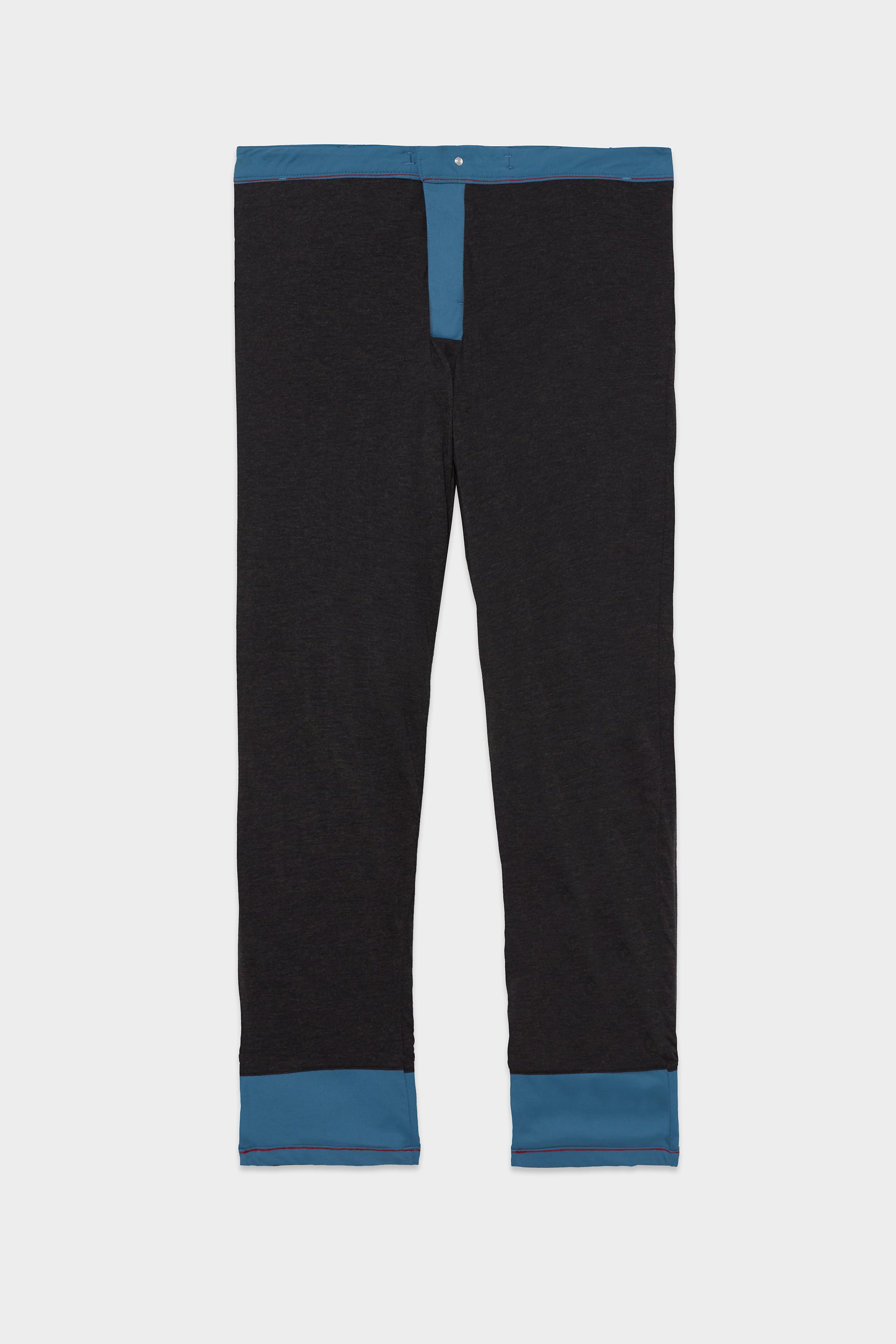 The 686 Men's Everywhere® Merino-Lined Pant - Relaxed Fit by 686 features black fabric with blue trim at the waistband, fly, and cuffs—ideal for pairing with your insulated outerwear for a sharp winter ensemble.