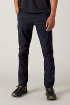 A person wearing black athletic shoes, a black shirt, and 686 Men's Anything Cargo Pant - Slim Fit by 686 with a 13-pocket design stands against a light background; only their lower half is visible—ready for any adventure.