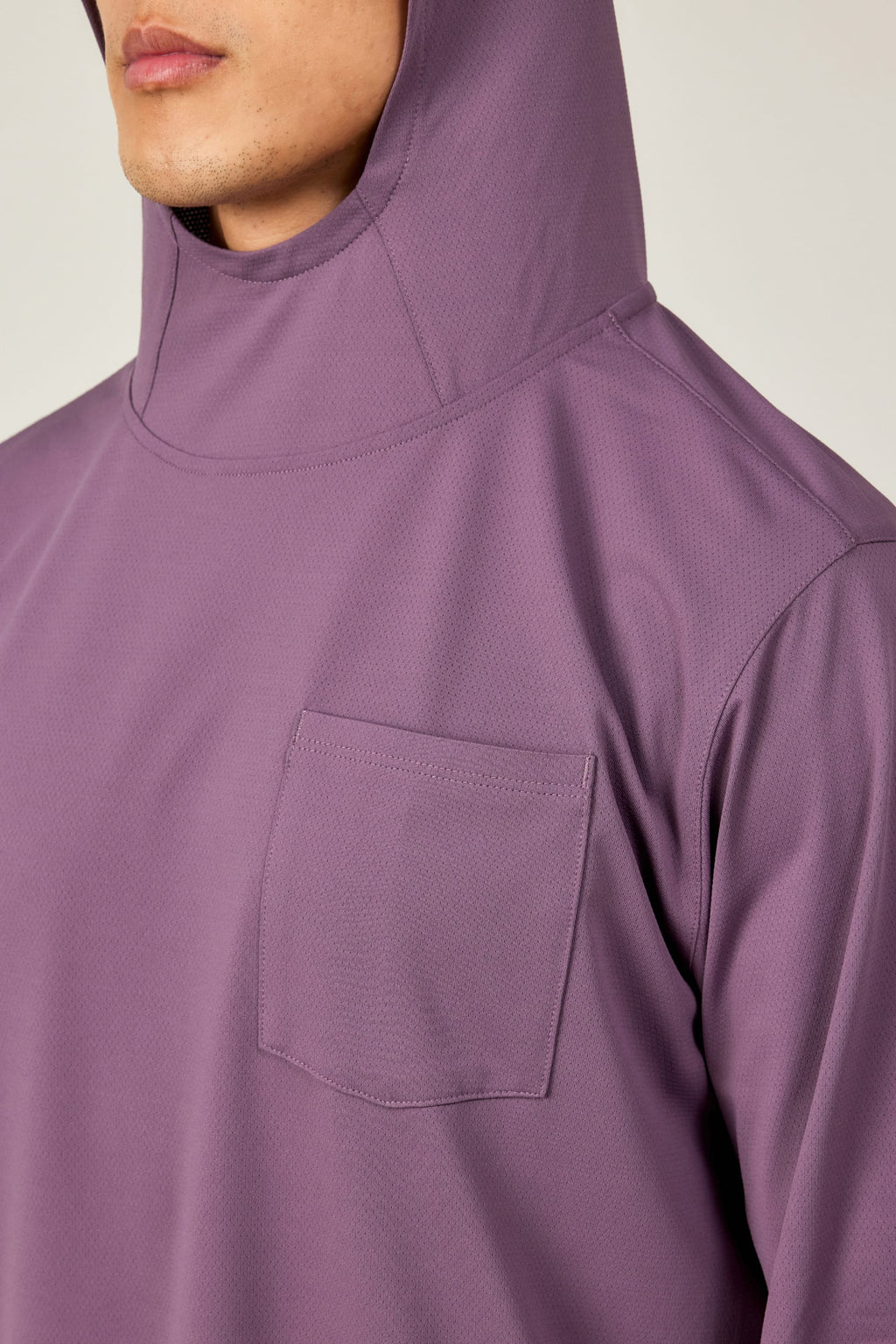 A person wears the 686 Mens Lets Go Tech Hoody in light purple, showcasing its lightweight, breathable design with a chest pocket. Only the lower face and upper torso are visible, emphasizing this 686 hoody’s ideal sun protection.