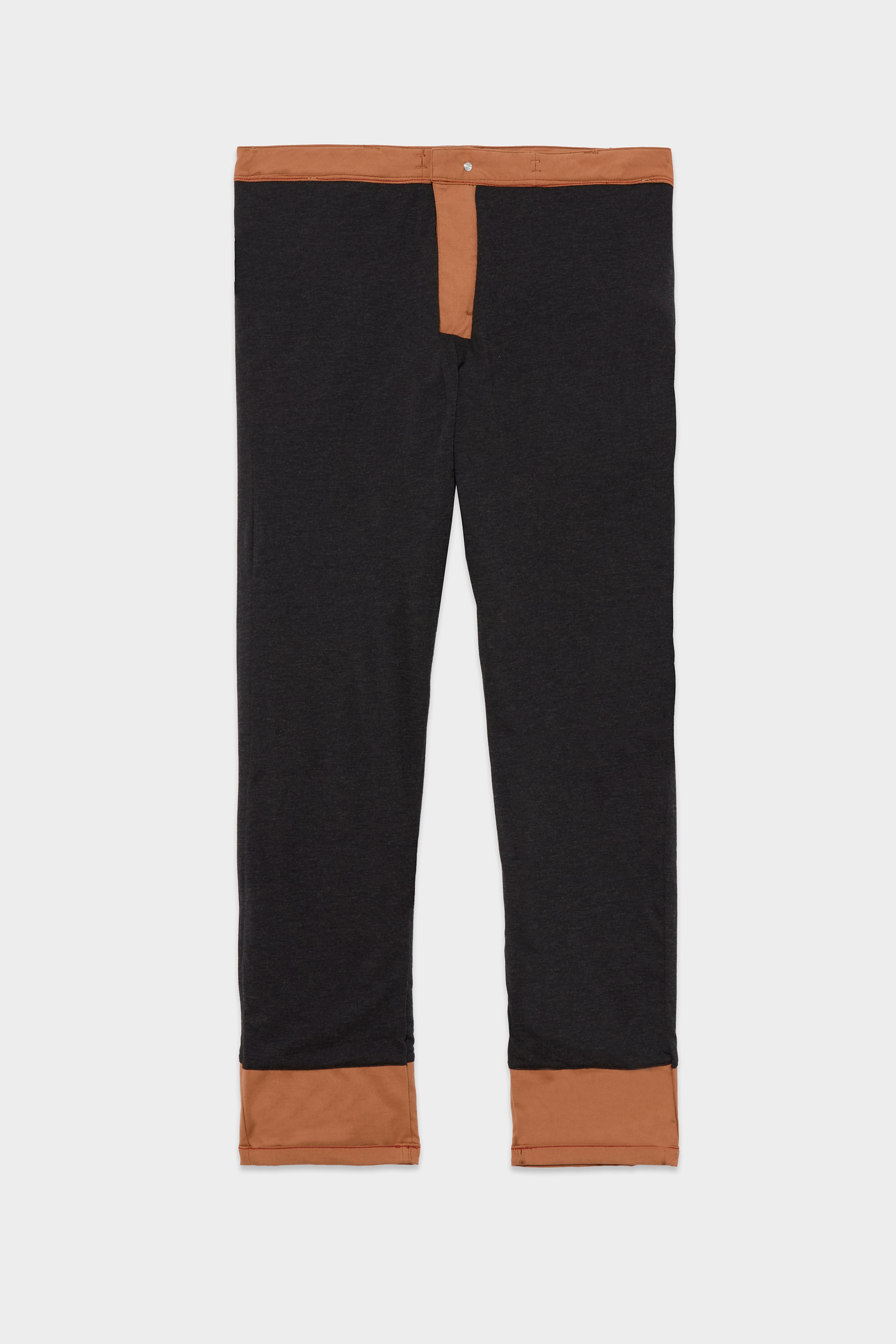 The 686 Men's Everywhere® Merino-Lined Pant - Slim Fit by 686 is a pair of black pants with brown trim at the waistband, fly, and cuffs, designed to keep you warm in cold weather, shown laid flat on a white background.