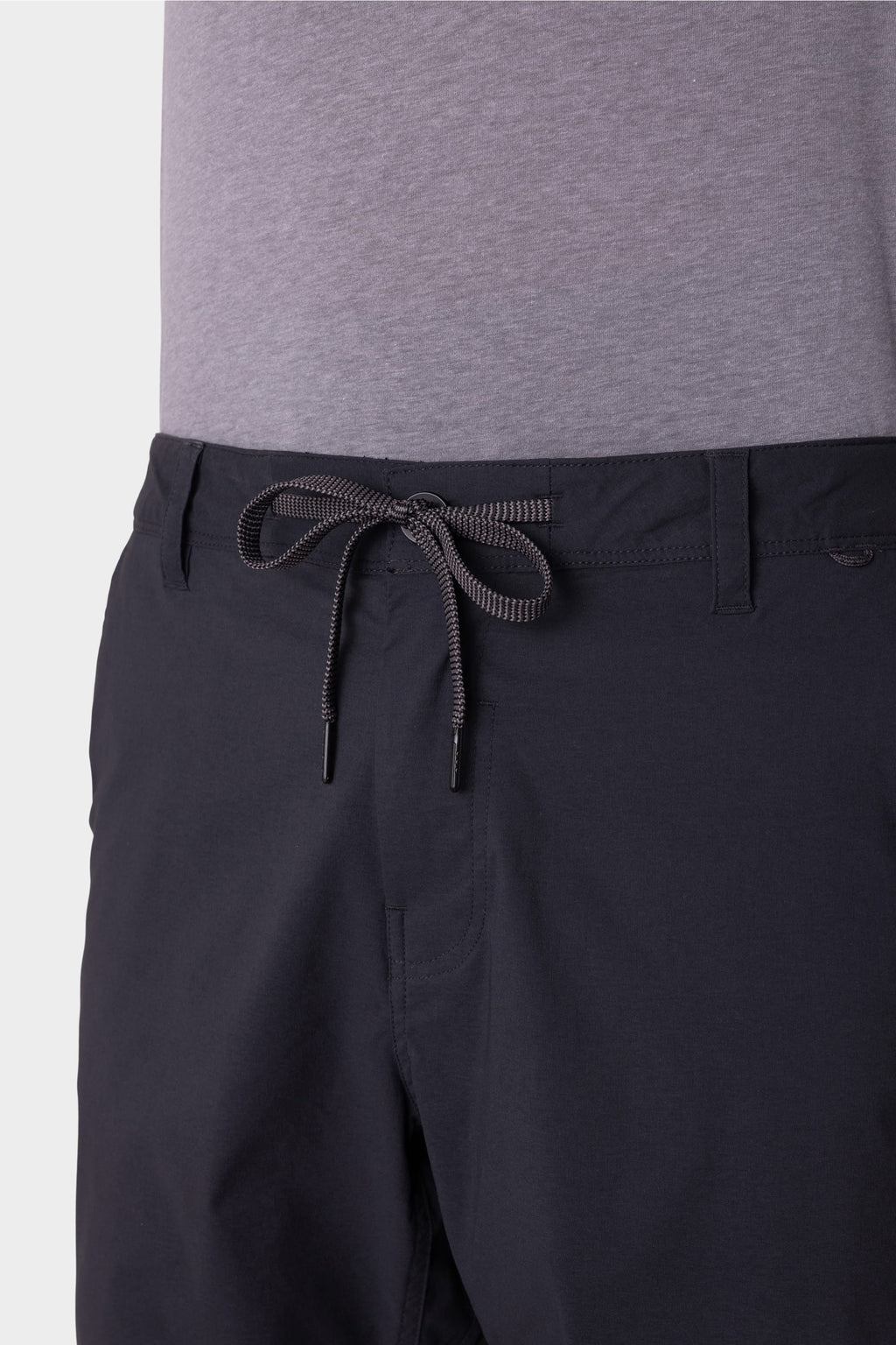A person wears a light gray t-shirt with 686 Men's Everywhere® Featherlight Chino Shorts, featuring an adjustable drawstring waistband, belt loops, and a breathable design. The image highlights the shorts' waist and upper legs. Brand: 686.