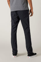A person stands facing away from the camera against a plain light background, wearing 686 Men's Everywhere® Featherlight Chino Pant - Slim Fit in dark navy—breathable pants ideal for any summer wardrobe.