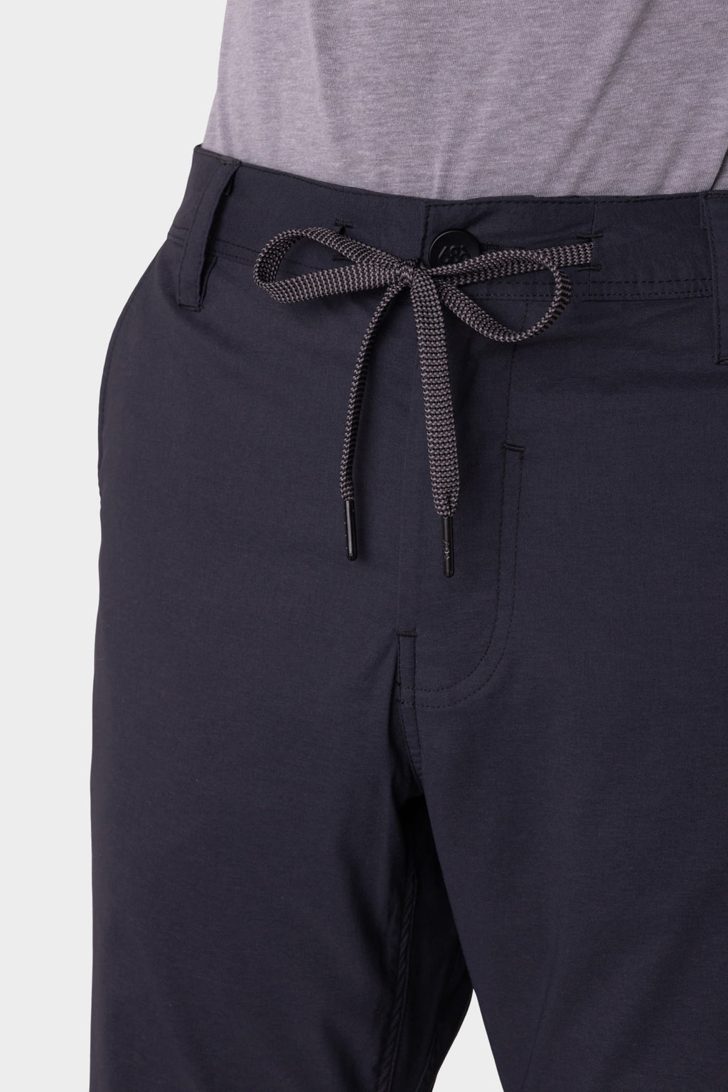 Close-up of a person wearing 686 Men's Everywhere® Featherlight Chino Pant - Slim Fit in dark navy with a light gray shirt. These breathable, lightweight chinos feature a drawstring waist and minimalist pocket stitching—ideal for summer.