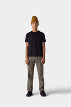 A person stands against a plain light gray background, wearing a mustard yellow beanie, olive green pants, black shoes, and the 686 Mens Everywhere drirelease® Tech Tee by 686. They face forward with a neutral expression.