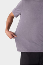 A person wearing the 686 Mens Everywhere drirelease® Tech Tee in grey pulls the side of the shirt outward with one hand, highlighting its stretch and fit. Only their upper body is visible; they also wear black pants.