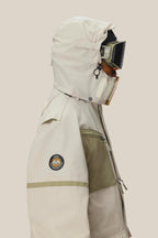 A person is shown in profile against a plain background, wearing the 686 Mens 2001 Transfer Jacket with a sleeve patch, plus ski goggles and a face covering.