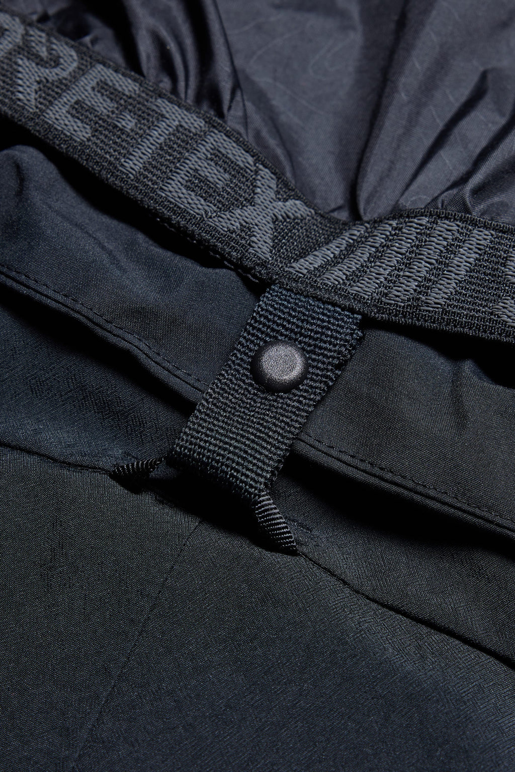 Close-up of the 686 Men's SMARTY® 3-in-1 Cargo Bib, featuring a GORE-TEX branded elastic waistband, snap button, and detailed fabric texture for a look at premium construction and design.
