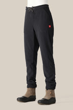 A woman wearing 686 Women's SMARTY® 3-in-1 Cargo Pant by 686 stands against a plain light beige background, pairing the versatile pants with brown slip-on boots.