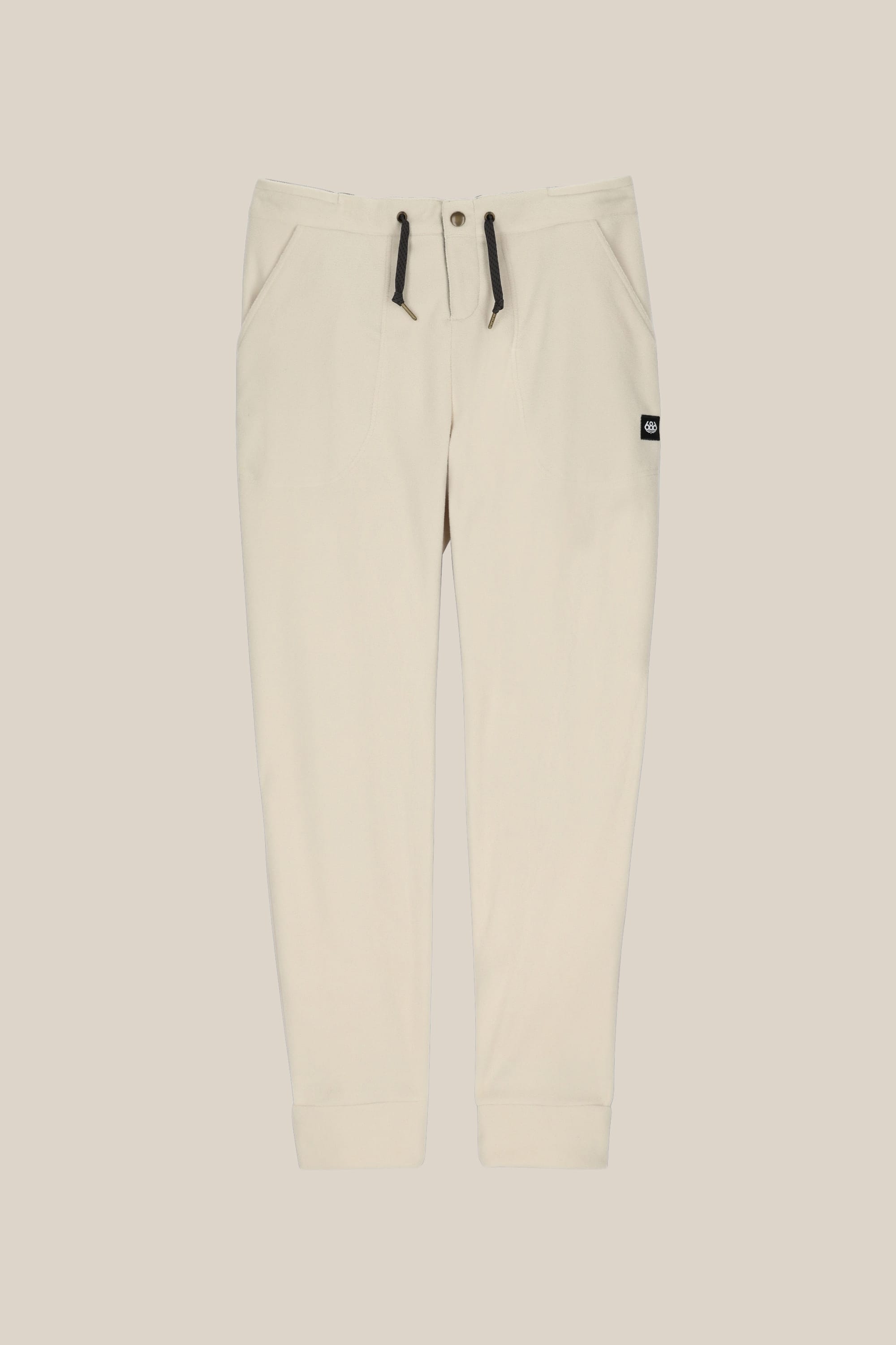 The 686 Women's SMARTY® 3-in-1 Cargo Pant features ribbed cuffs, two side pockets, a drawstring waistband with black ties, three ways to wear, and a small black logo tag on the right pocket. Shown against a light beige background.
