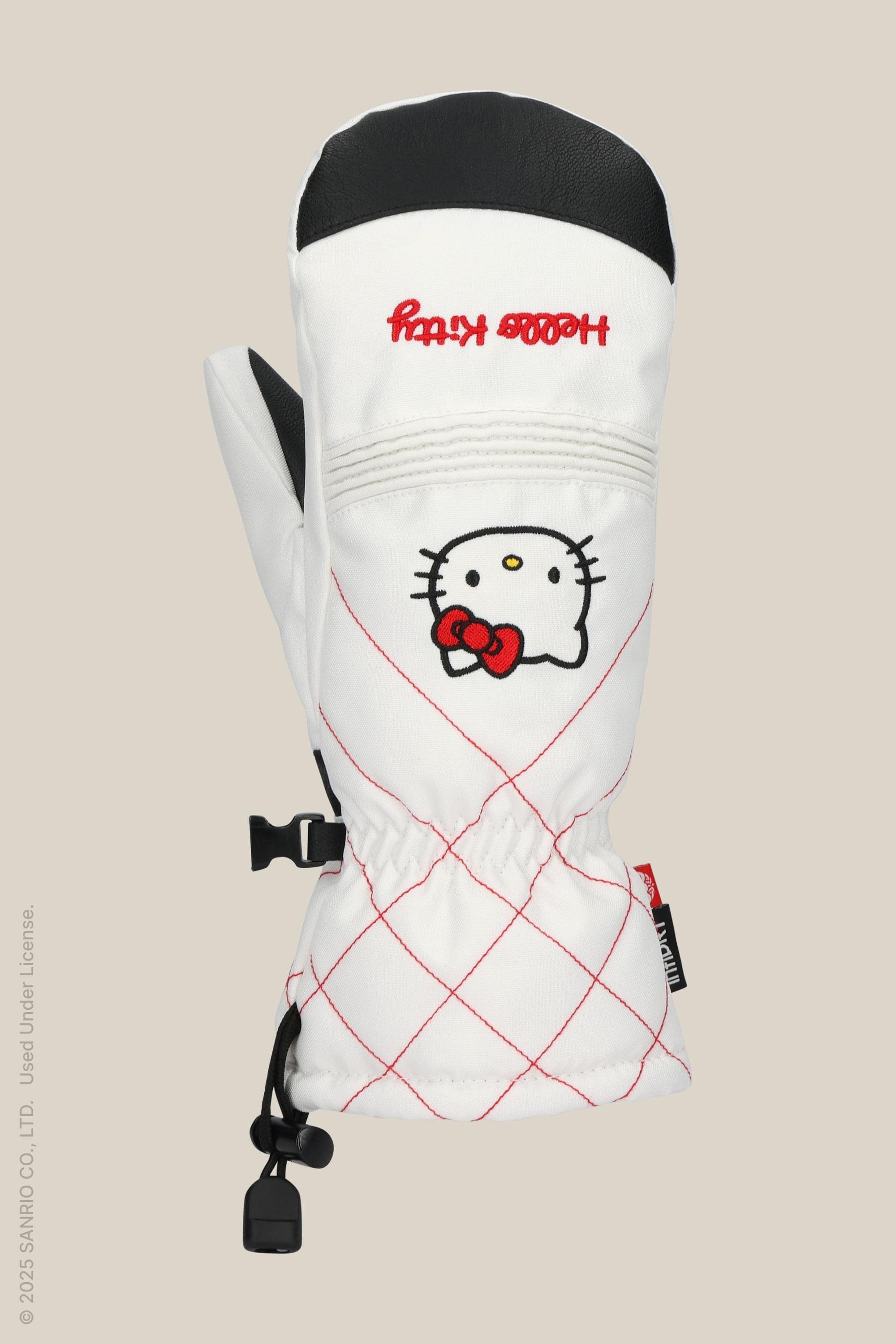 The 686 Women's Jubilee™ Mitt by 686 is a white waterproof mitten with light insulation, red stitching, Hello Kitty face and red bow on back. It has a black thumb grip, drawstring wrist, and playful decorative red text.