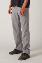 A person wears 686 Men's Unwork® Pant - Relaxed Loose Fit in light gray with dark gray lace-up shoes, standing against a plain, light background. Only the lower half of the body is shown. Brand: 686.