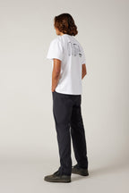 A man in a white shirt and 686® Men's Unwork® Pant - Slim Fit.