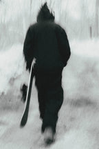 Wearing the 686 Ghost™ 2.5L Pant by 686, a person in dark winter clothes strolls down a snowy path with a snowboard in hand. The blurred image adds a dreamy, ethereal vibe to the scene.