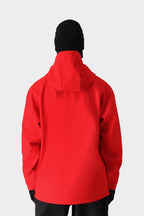 A person wearing the 686 Mens Waterproof Hoody in bright red, paired with a black beanie, black gloves, and black pants, stands with their back to the camera against a plain light gray background.