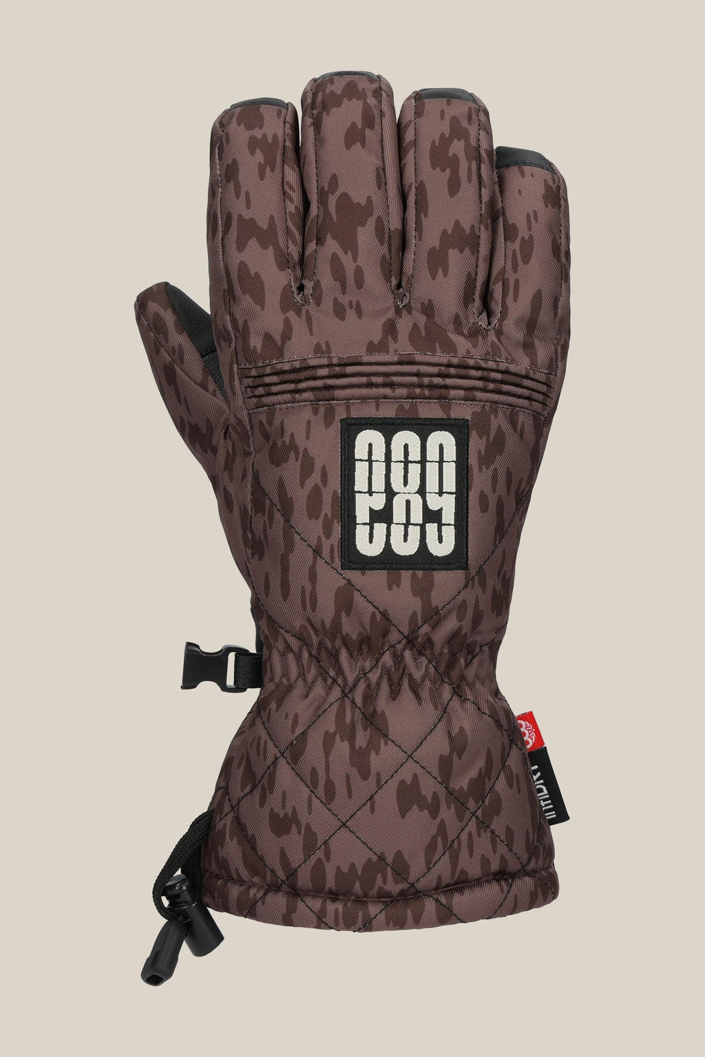 The 686 Women's Jubilee™ Glove features a brown camo pattern with black accents, adjustable wrist strap, a rectangular patch with white "686," plus a black clip and drawstring for convenience.