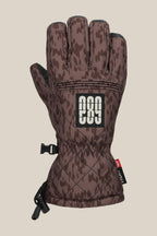 The 686 Women's Jubilee™ Glove features a brown camo pattern with black accents, adjustable wrist strap, a rectangular patch with white "686," plus a black clip and drawstring for convenience.