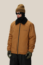 A person wearing the 686 Mens Caim Insulated Jacket by 686, paired with a brown beanie, black sunglasses, black scarf, and camouflage gloves stands against a plain beige background.