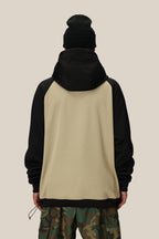 A person wearing the 686 Mens Bonded Fleece Pullover Hoody in beige and black, paired with a black beanie and camo pants, stands facing away from the camera against a plain light beige background.