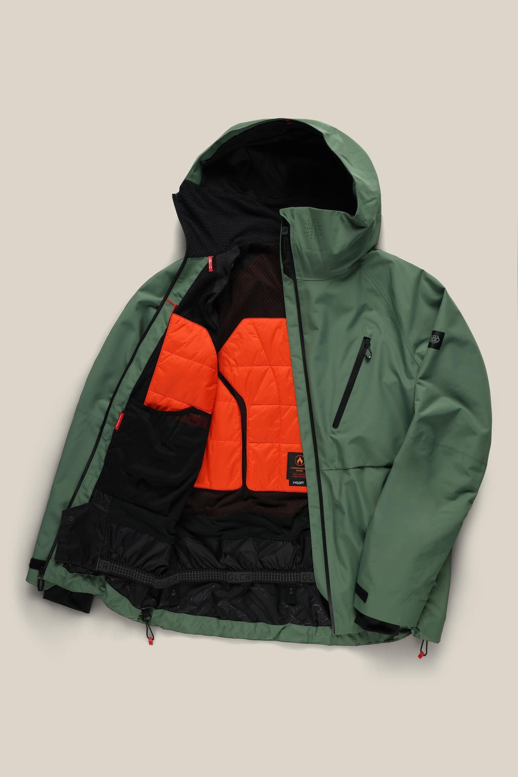 The 686 Men's Hydra™ Thermagraph® Jacket in green is shown open, revealing a vibrant orange quilted lining and black mesh pockets. This do-it-all 686 jacket also features a zippered chest pocket and adjustable cuffs.