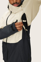 A person zips open the underarm vent of the 686 Men's Hydra™ Thermagraph® Jacket, revealing its color-blocked design and body-mapped lining. Only the lower half of their face is visible.