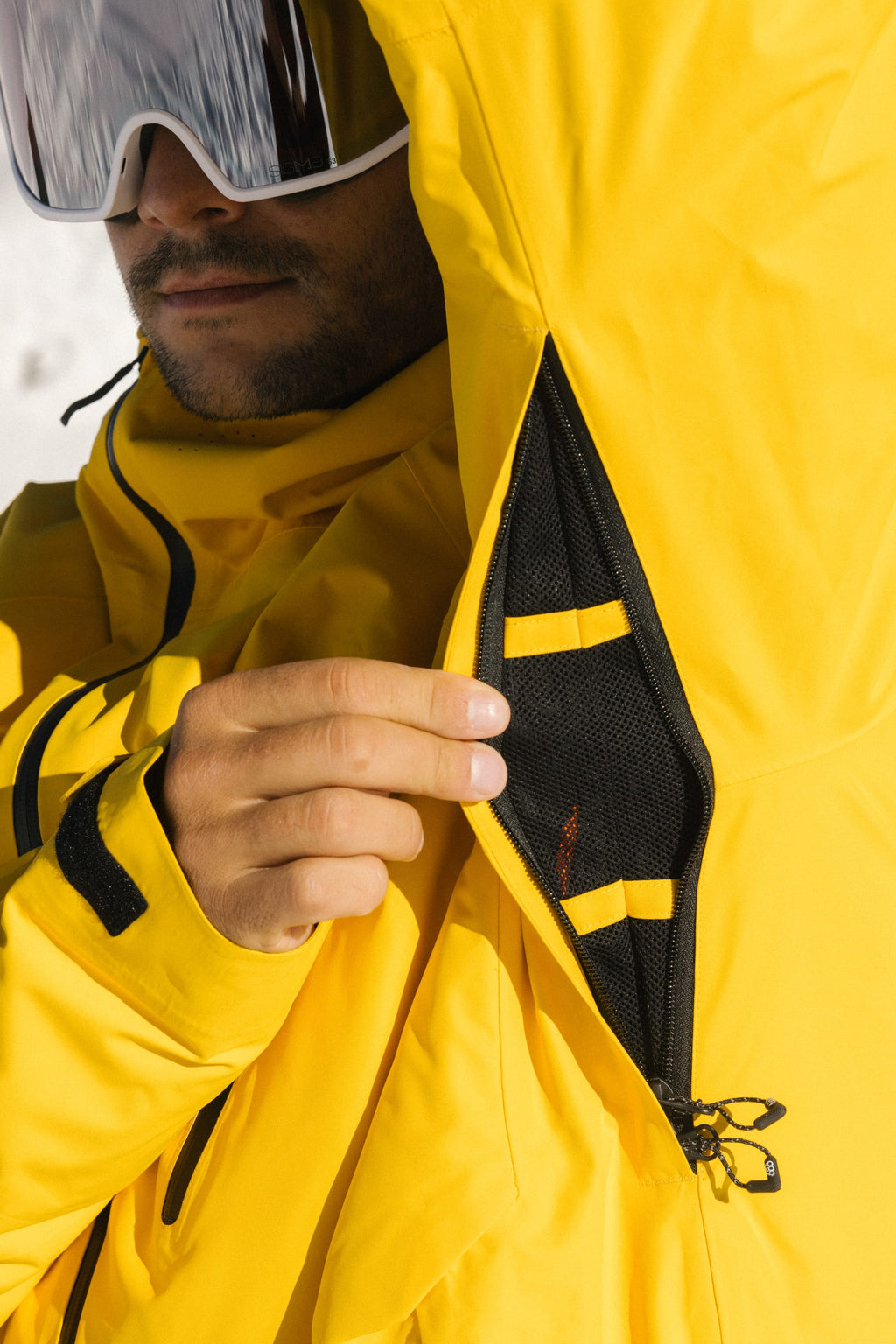 A person in the 686 Men's Hydra™ Thermagraph® Jacket unzips an underarm vent, revealing the body-mapped lining inside this versatile 686 ski jacket.