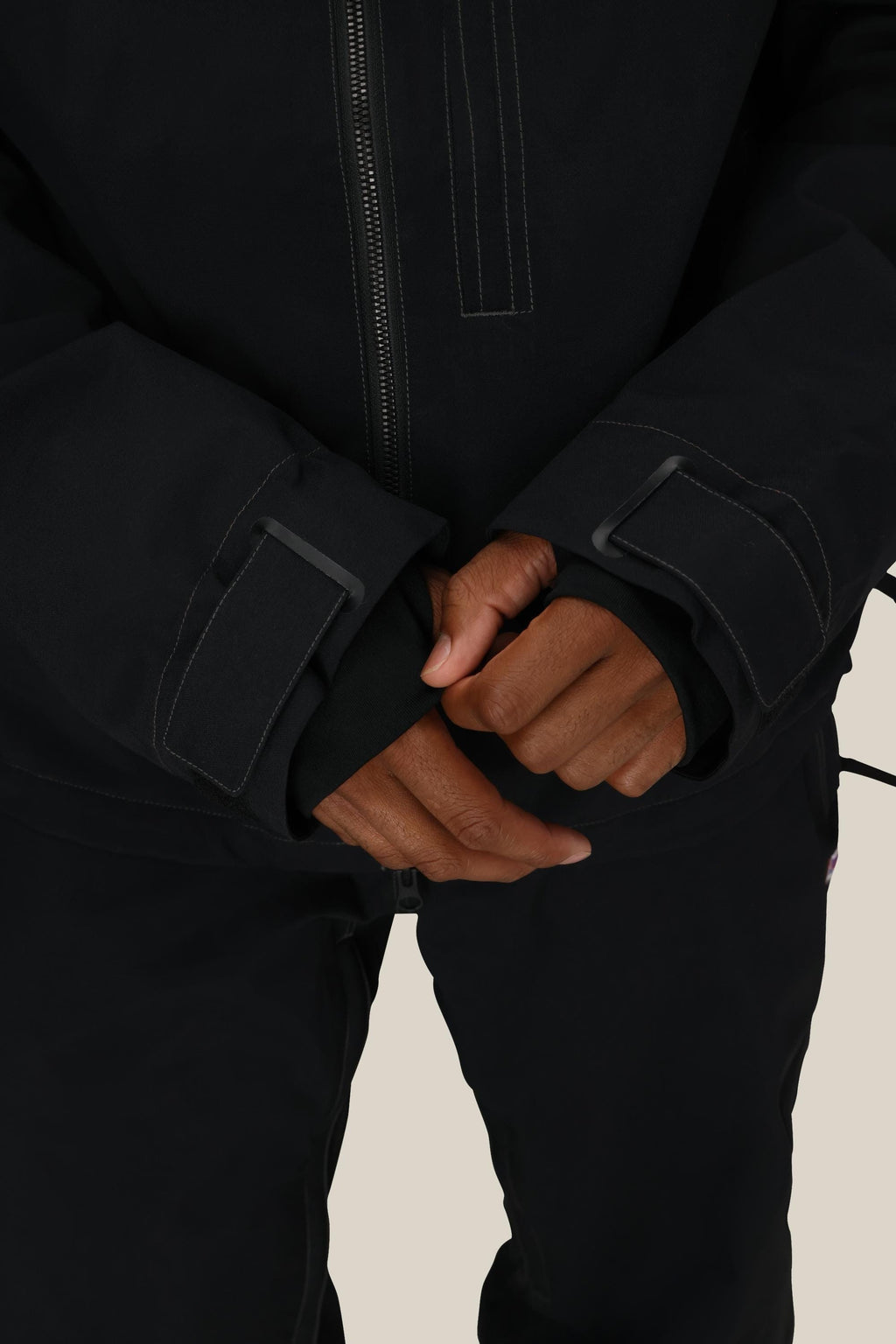 A person wearing the 686 Dojo® Jacket by 686 fastens the Velcro strap on one sleeve while holding the other cuff, against a plain light background.