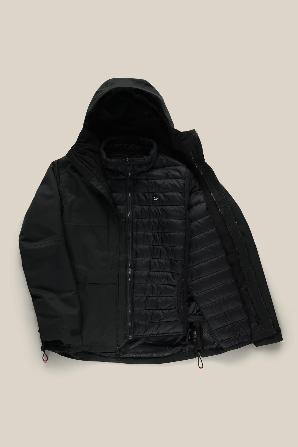 The 686 Men's SMARTY® 3-In-1 Form Jacket in black is shown unzipped against a beige background, revealing its quilted, horizontally stitched liner. Adjustable drawstrings at the hem and cuffs ensure a customizable fit.