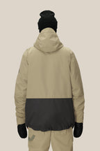 Against a plain light background, a person is shown from the back wearing the 686 Men's SMARTY® 3-In-1 Form Jacket in beige and black, along with beige pants, black gloves, and a black beanie.