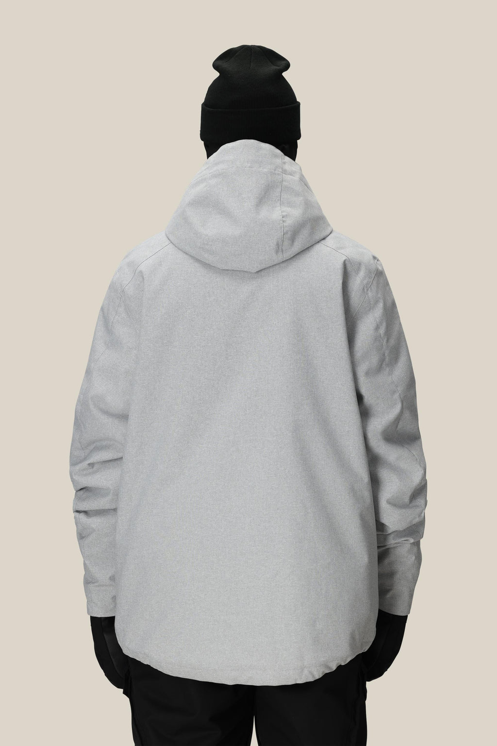 A person is shown from the back against a plain beige background wearing the 686 Men's Nightline™ Insulated Jacket in light gray, paired with a black beanie, black gloves, and black pants.
