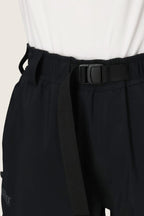 Close-up of a person wearing 686 Dojo® GORE-TEX Pant by 686, featuring an adjustable black webbing belt with a black plastic buckle, paired with a white top.