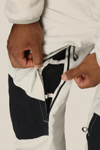 Someone unzips a black and white pocket on the 686 Men's GORE-TEX Dispatch™ Shell Bib, revealing a mesh lining inside.