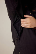 A hand unzips a hidden zipper under the arm of the 686 Women's SMARTY® 3-In-1 Spellbound Jacket, revealing its inner lining.