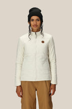 A person wearing the 686 Women's SMARTY® 3-In-1 Spellbound Jacket in white stands against a plain beige background, facing forward with a neutral expression.